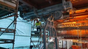 photo og a Vestadvit engineer on scaffolding, servicing a davit system